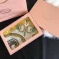 Detailed view of luxury silk square scarf inside pink gift box featuring classic ornate gold patterns. - Pink Set Box With Rigid Corrugated Box
