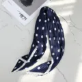 Close-up of pleated navy blue neck scarf with white polka dots and elegant contrast border. - 70x70cm / Navy Blue