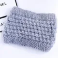 Detailopname van de grijze pluizige gebreide winter oorwarmer haarband zachte textuur. - Grijs
