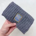 Detailed view of the dark gray knitted hair band with embroidered patch for daily wear. - Gray