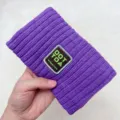 Close-up detail of a purple knitted hair band with embroidered patch letter design, cozy texture. - Purple