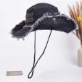 Distressed black denim bucket hat with chin strap, vintage cowboy sun cap for outdoor travel. - Black