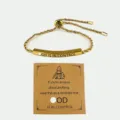 Bracciale regolabile in corda di acciaio al titanio inciso con biglietto motivazionale - God Is In Control / Oro