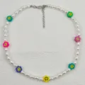 Vista ravvicinata e dettagliata della collana di perle con fiori sorridenti colorati. - Faccina sorridente con fiori e perle