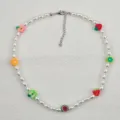 Dettaglio in primo piano della collana di perle boho con ciondoli di frutta in argilla polimerica. - Frutta di perle