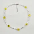 Dettaglio in primo piano della collana di perle bianche con perline smiley gialle e catena. - Faccina Sorridente di Perla