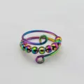 Nahaufnahme des Regenbogen-Anti-Stress-Rings mit beweglichen Perlen auf Draht. - bunt