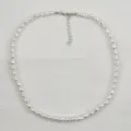 Collana di perle bianche con catenella di estensione in metallo, dettaglio gioiello elegante. - Perla barocca