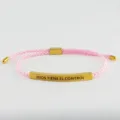 Primo piano del bracciale in corda intrecciata rosa con tubo in metallo dorato inciso. - DIOS TIENE EL CONTROL (B240303002) / Oro/Rosa