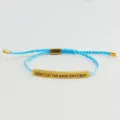 Primo piano dettagliato del bracciale in corda intrecciata azzurra con barra dorata. - Tubo Oro - Corda Blu Lago (Con Cartolina)