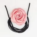 Vista in primo piano dettagliata dell'elegante collana choker con fiore in tessuto rosa. - Rosa