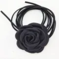 Dettaglio della collana girocollo con fiore di camelia in tessuto nero e lunghi lacci scamosciati. - Nero