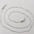 Gros plan détaillé de la chaîne de lunettes en métal argenté avec boucles en silicone et mousquetons. - Argent