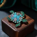 Primo piano dettagliato di una spilla tartaruga in strass di lega creativa con cristalli. - Celeste