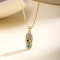 Detail shot of gold evil eye slipper necklace pendant sparkling pavé stones luxury style - Yellow