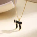 Detail view of a gold chain necklace with a black enamel Hebrew Chai pendant and beaded edges. - Black Enamel Symbol Style (N2152) / Black