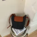 Chic dark grey denim bucket shoulder bag with brown leather flap and adjustable strap for women. - Black