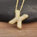 Collana con ciondolo a lettera X dorata con pavè di zirconi scintillanti su catenina a sfere. - Lettera X