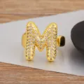 Vergoldeter, aufgeblasener Buchstabe M Ring mit funkelnden Zirkoniasteinen, verstellbar. - Buchstabe M Stil / Verstellbare offene Größe / Gold