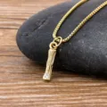 Gold-plated branch pendant necklace with sparkling crystal detail, minimalist fashion style. - Letter I
