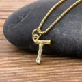 Gold plated initial letter T pendant necklace with tiny crystal on rustic wood stone backdrop - Letter T
