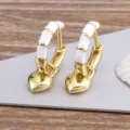 Gold plated hoop earrings with white enamel segments and cute dangling heart charms. - White