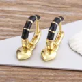 Gold-plated hoop earrings featuring black enamel segmented details and a cute dangling heart pendant. - Black