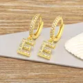 Gold-plated copper letter E hoop earrings sparkle with cubic zirconia for daily wear. - Letter E