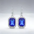 Primo piano dettagliato di eleganti orecchini pendenti in cristallo blu con strass. - Argento + Blu Reale