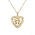 Gold heart pendant necklace featuring white enamel bow and elegant faux pearl border design. - Necklace / White