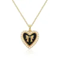 Close-up detail of the gold-tone heart pendant necklace with black enamel, bow, and faux pearls. - Necklace / Black