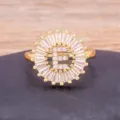 Gold plated 18K letter E ring with sparkling cubic zirconia baguette halo style jewelry item. - Letter E