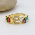 Anello in rame placcato oro 18k con pietre zirconi multicolore e ciondolo con lettera E. - Lettera E
