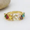 Elegante anello regolabile in rame placcato oro 18k con zirconi colorati e lettera K. - Lettera K