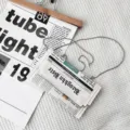 Detailed shot of the newspaper print PU envelope crossbody bag featuring metal chain strap. - White
