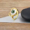 Gold plated adjustable ring featuring a unique green evil eye and heart design for women. - Green