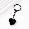 Close-up detail of black heart-shaped locket keychain, metal photo holder pendant ring. - Heart Locket Keychain / Black