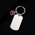 Close-up detail of stainless steel dog tag keychain with red glitter paw pendant accessory. - Military Tag (50X28mm) with Red Glitter Dog Paw / Silver