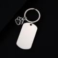 Close-up of stainless steel military dog tag and cute paw print keychain pendant. - Military Tag (50X28mm) with Black Glitter Dog Paw / Silver