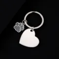 Detail shot of blank stainless steel keychain featuring heart pendant and cute glitter dog paw charm. - Slanted Heart (30*28.5mm) with Gray Glitter Dog Paw / Silver