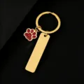 Detailed close-up of gold-tone metal keychain featuring red glitter paw charm and blank tag. - Rectangle Bar (50X12mm) with Red Glitter Dog Paw / Gold