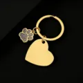 Close-up detail of the gold metal keychain featuring a sparkling glitter paw and heart pendant. - Slanted Heart (30*28.5mm) with Gray Glitter Dog Paw / Gold