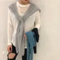 Detailansicht des stilvollen Strickschals am Model, der vielseitigen Fall zeigt. - Grau