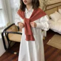 Weisses langaermeliges Hemd kombiniert mit einem rostroten Strickschal, elegant und gemuetlich. - Ziegelrot