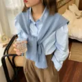 Detailaufnahme des blauen Strickschals kombiniert mit Hemd im gemütlichen Innenszenario. - Himmelblau