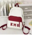 Vista detallada de una mochila casual blanca y burdeos con bordado KMG en el escritorio. - Bolso Individual / Burdeos