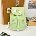Light green canvas backpack detail with plush star decor and colorful bead charms. - Star Safety Pin Style / Green