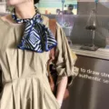 Vista dettagliata di un foulard in seta di lusso con motivo geometrico, elegante accessorio. - J610