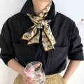 Dettaglio sciarpa di seta con stampa farfalla al collo, accessorio elegante per uso quotidiano. - J408
