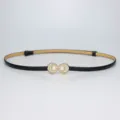 Detailed shot of a sleek black thin leather belt featuring elegant pearl shell buckle. - Black